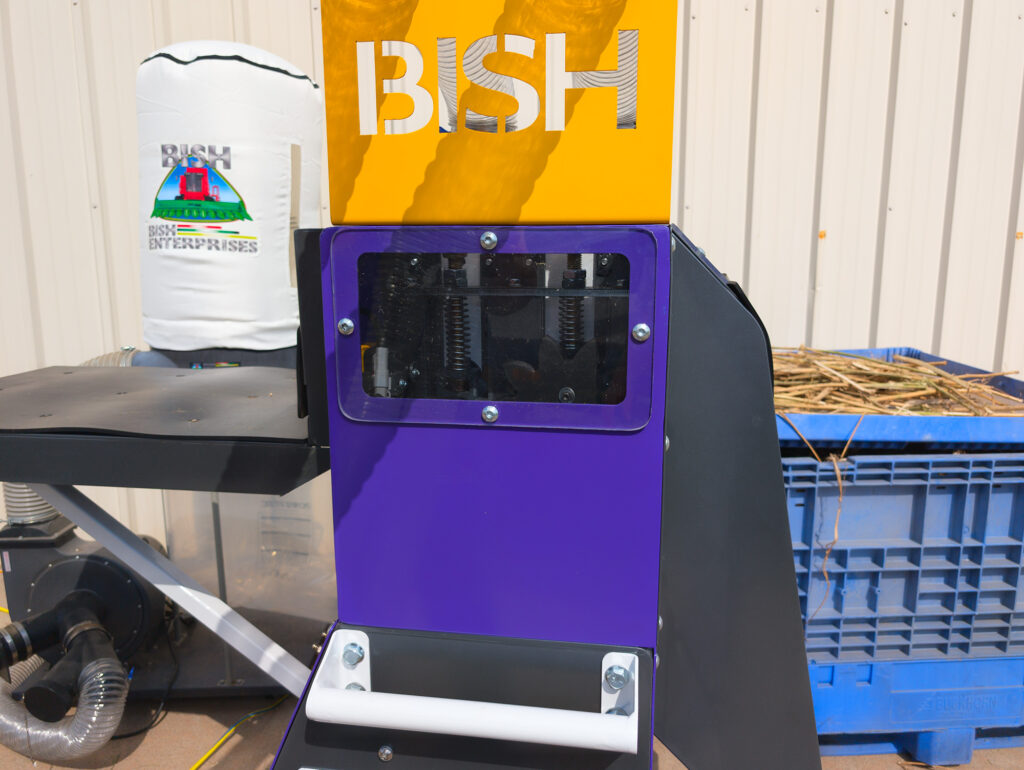 Close-up view of Bish Decorticator discharge area where processed hemp material exits