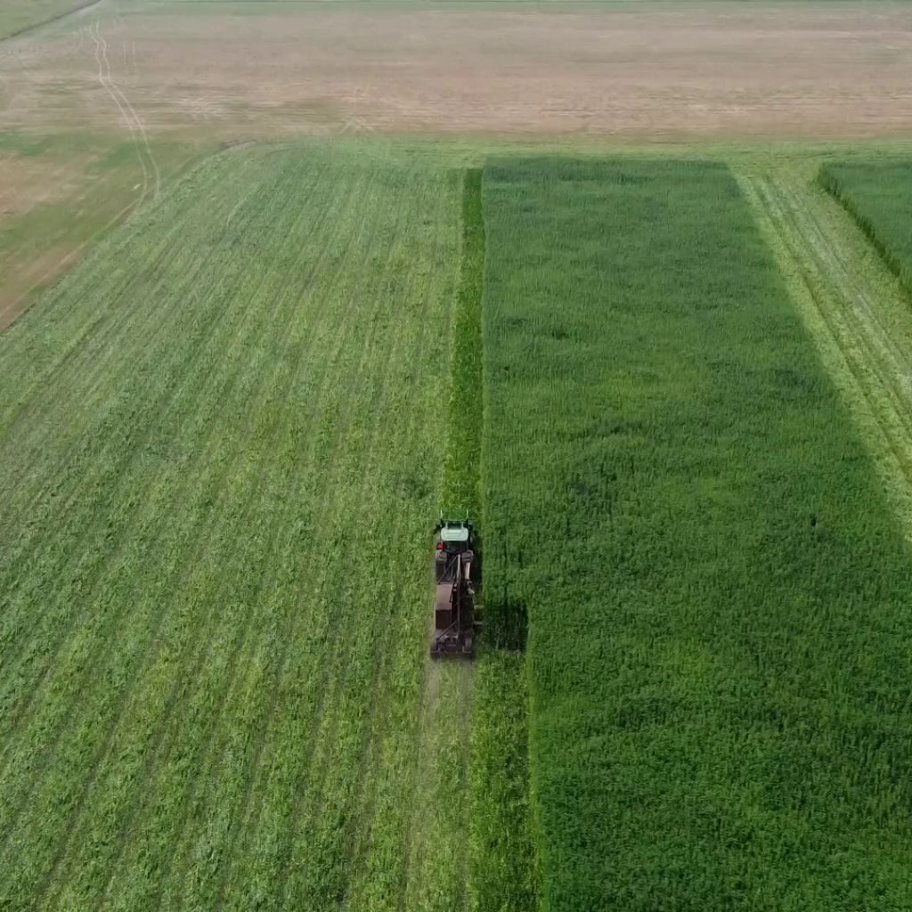 Tractor-pulled FiberCut machine operating in a lush green field